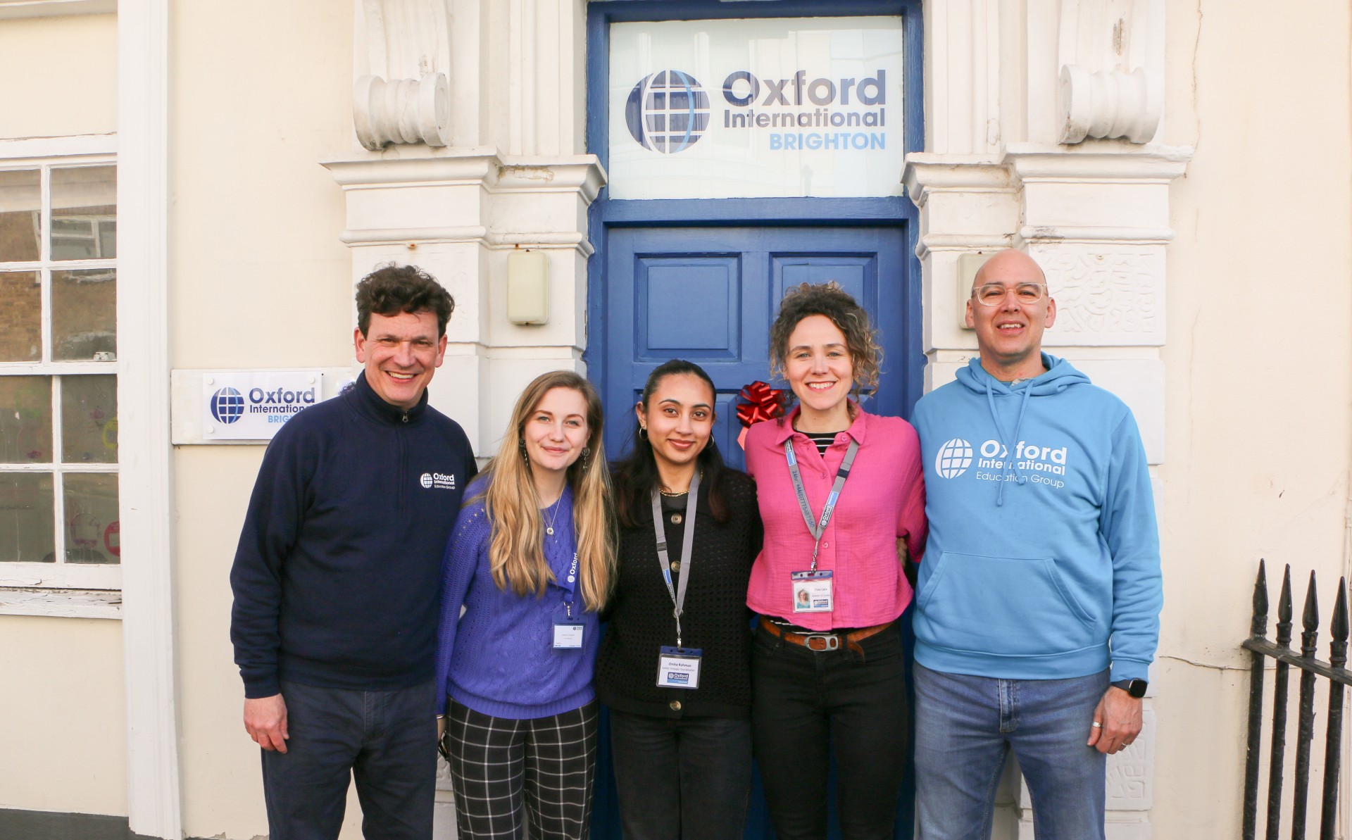 Team members, stood smiling outside of the Brighton Centre